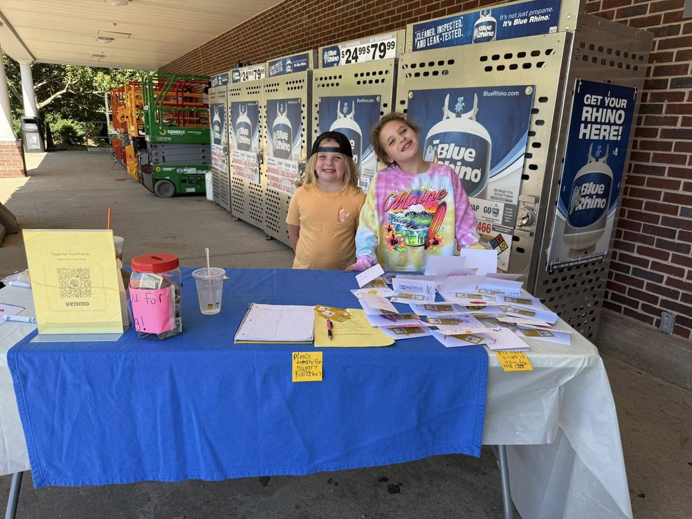 Young volunteers running a food drive table